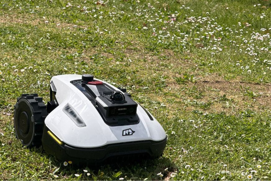 Mammotion YUKA mini 2 auf gemähtem Rasen mit sichtbaren strukturierten Mähbahnen im Schachbrettmuster